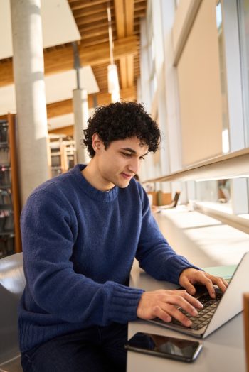 Dark-haired,Positive,Latin,Young,Man,,Using,Laptop,,Doing,Researches,On